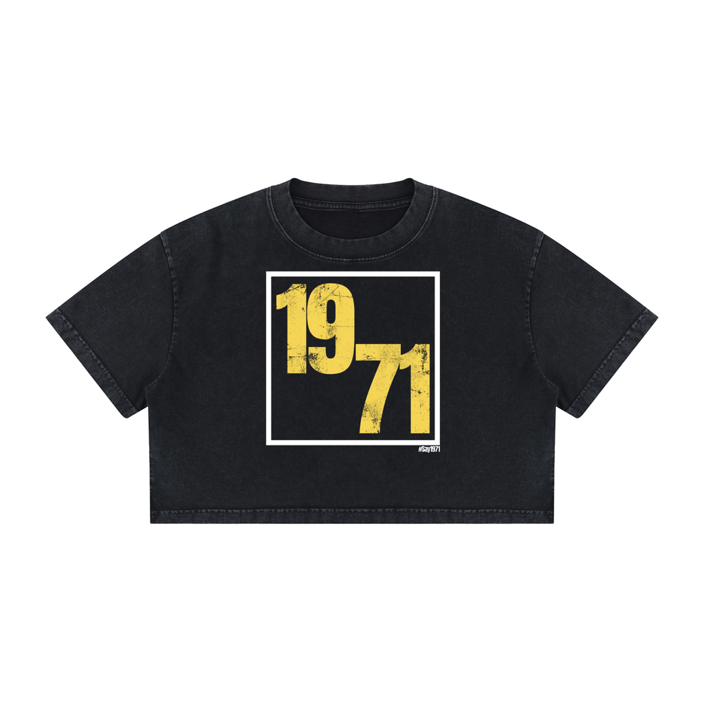 A black cropped t-shirt featuring a distressed yellow '1971' graphic inside a white square frame on the front, displayed flat against a solid white background.
